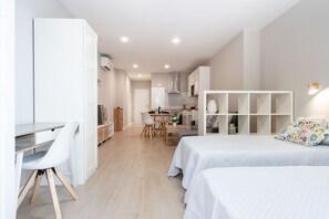 Een moderne, goed verlichte slaapkamer met een bed, nachtkastjes en een groot raam.