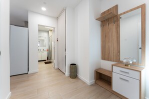 A modern bathroom with a wooden vanity, a mirror, and a shower area. - MalagaSuite Urban Beach E (Torremolinos)