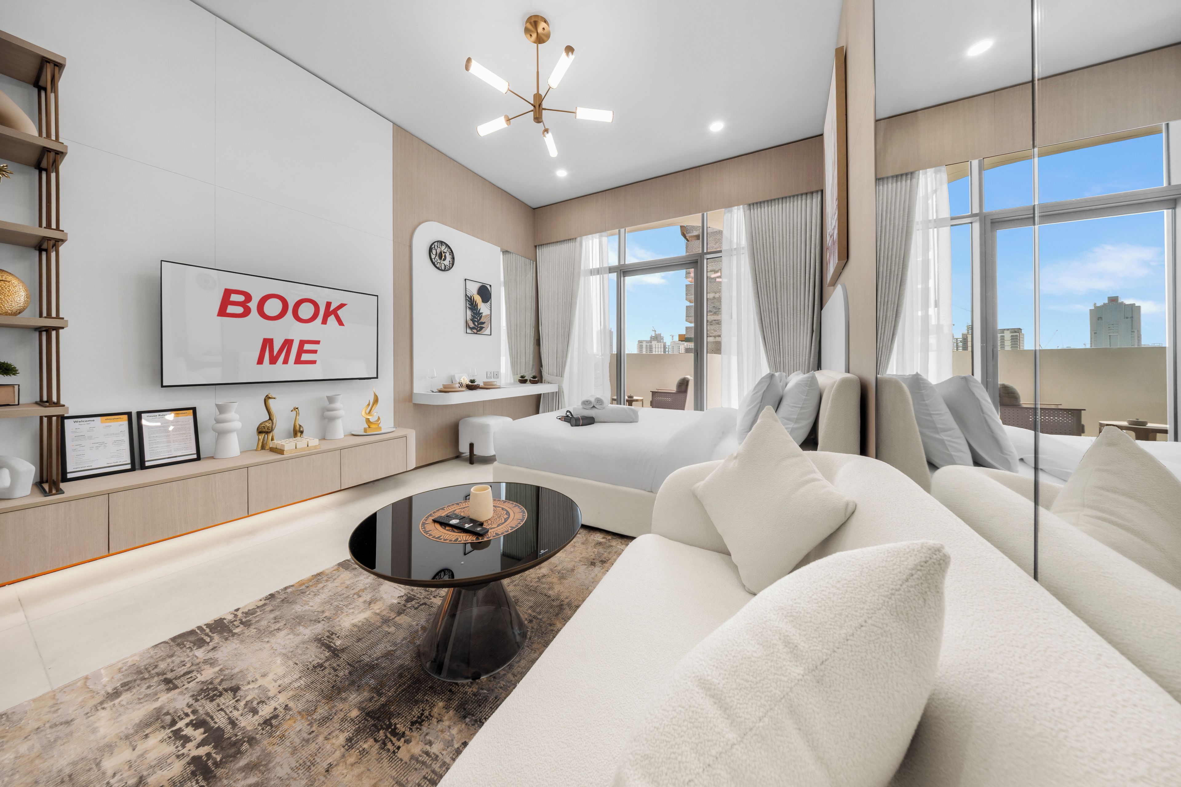 Une chambre d’hôtel moderne équipée d’un canapé, d’une table basse, d’une télévision et d’une grande fenêtre donnant sur la ville.