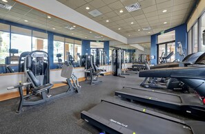 A gym with cardio equipment, weight machines, and mirrors. - 4BR townhouse at Regal Oaks (Kissimmee)