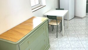 A small, clean kitchen with a white refrigerator, a wooden cabinet, and a window. - Verde Salvia Home - Vacation Rental in Frascati (Frascati)