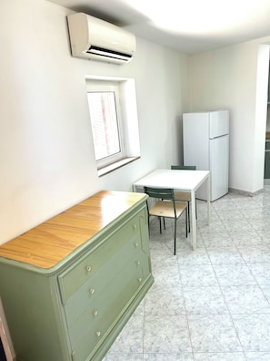 A small, clean kitchen with a white refrigerator, a wooden cabinet, and a window. - Verde Salvia Home - Vacation Rental in Frascati (Frascati)