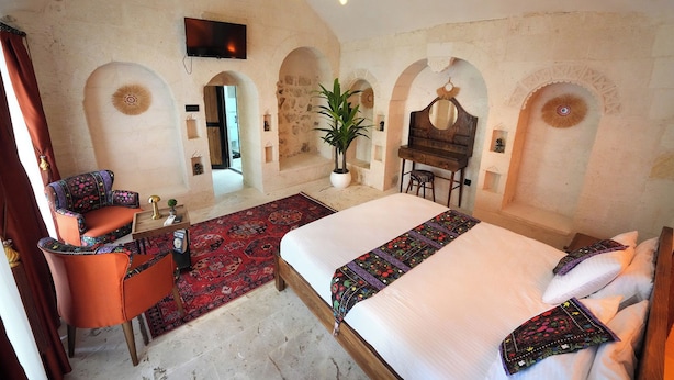 A bedroom with a bed, a desk, a chair, and a television. - NUHARA OTEL (Mardin)
