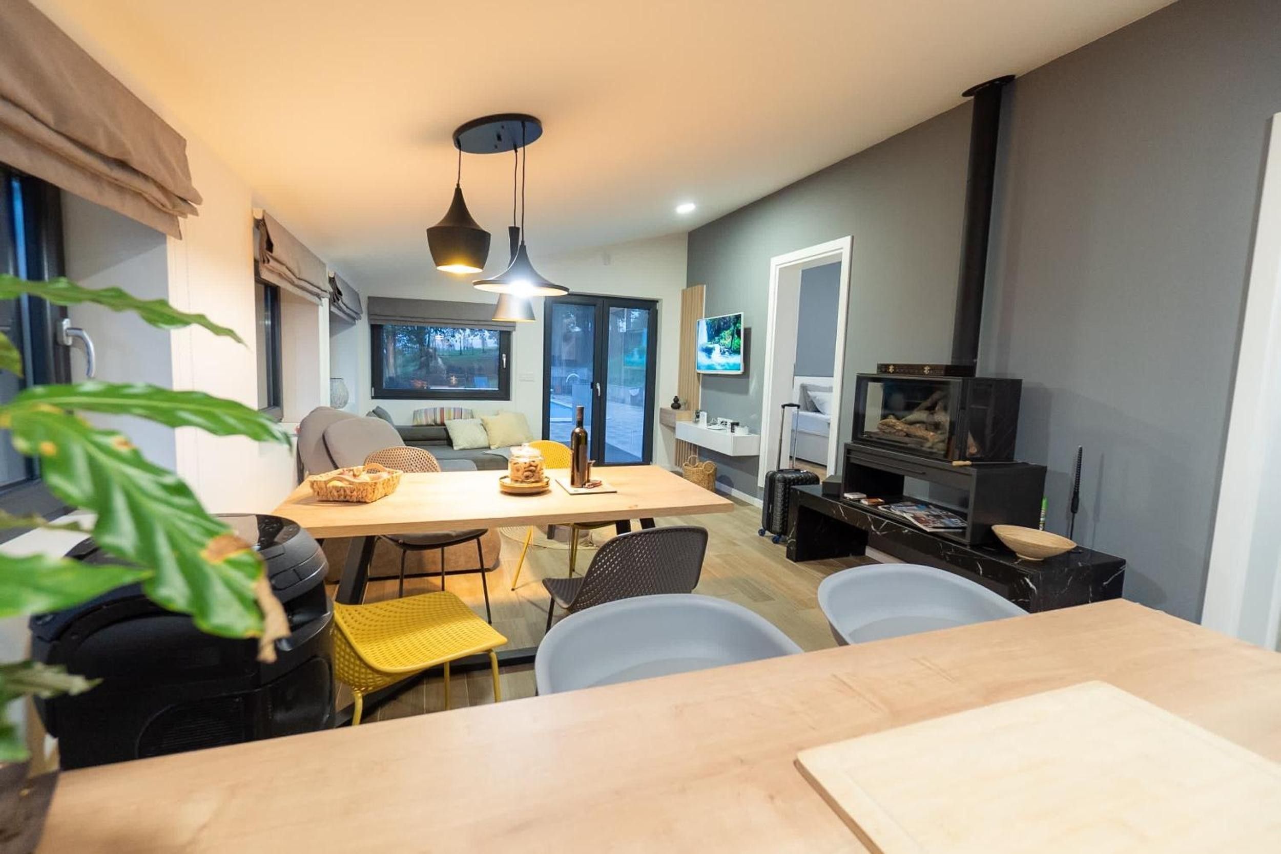 Ein modernes Wohnzimmer mit Essbereich, Fernseher und Kamin.