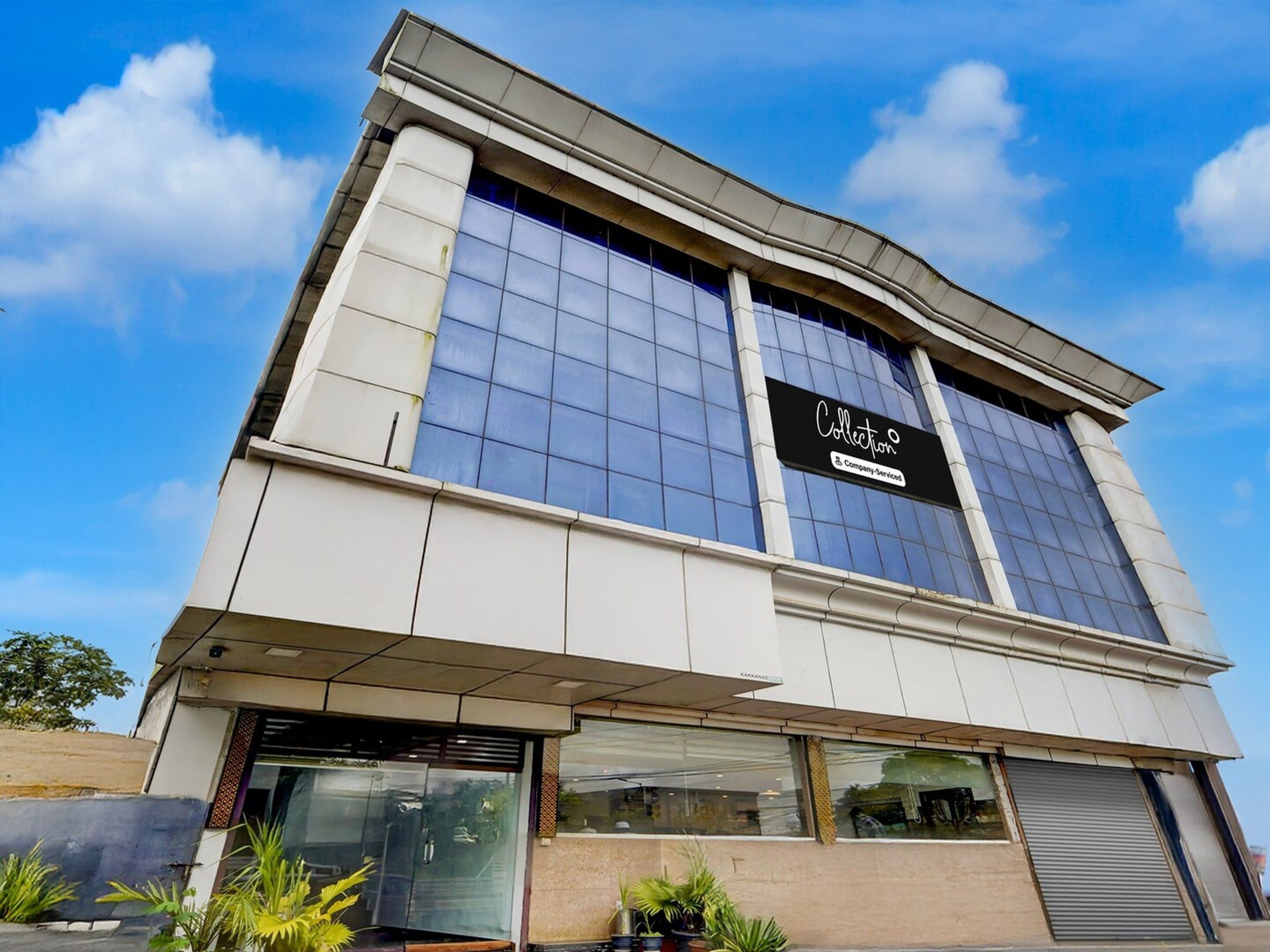 A modern building with a large glass facade, a sign reading 'Collection Company Services', and a flat roof.