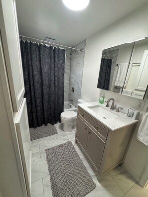 Une salle de bain moderne équipée d’une douche, de toilettes et d’un lavabo.