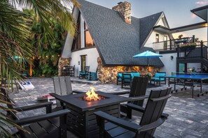 An outdoor patio with a fire feature, seating, and a pool area. - 3 beds/2.5 bath, A-Frame Palm Tree & Alpaca & Llama Farm (Palm Beach Gardens)