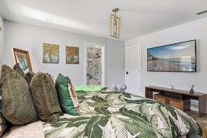 A bedroom with a bed, pillows, a TV, and artwork on the wall. - 3 beds/2.5 bath, A-Frame Palm Tree & Alpaca & Llama Farm (Palm Beach Gardens)