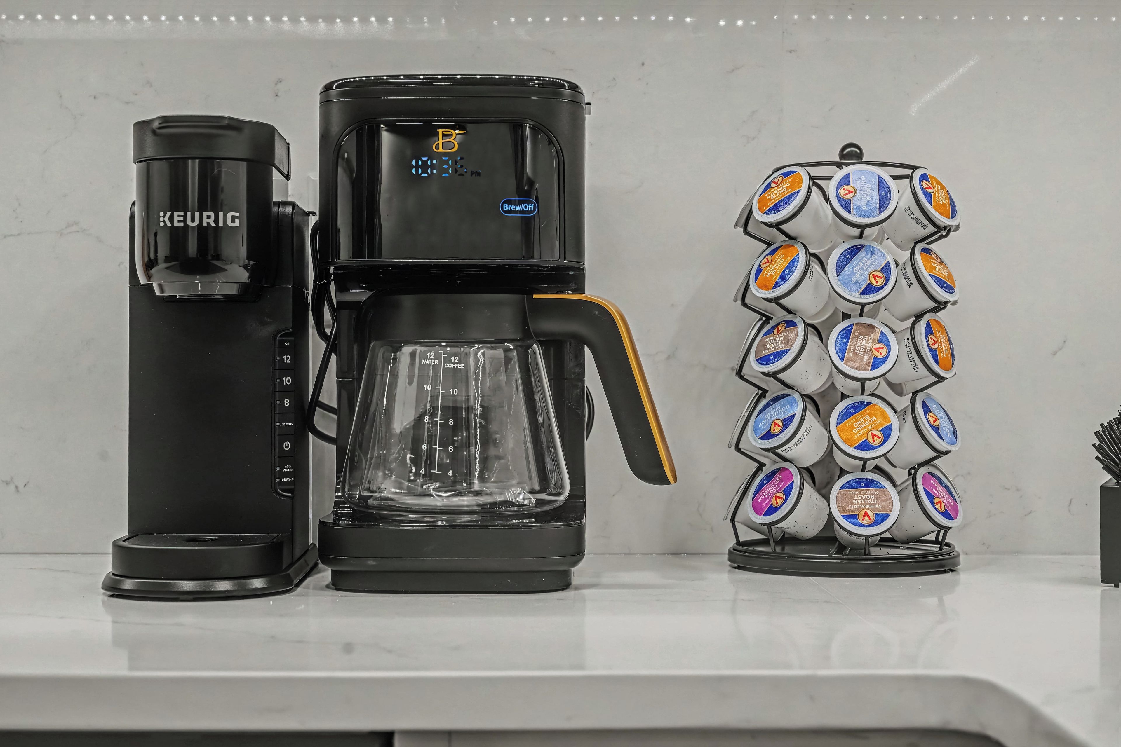 Una cafetera con pantalla digital, depósito de agua y compartimento para cápsulas de café.