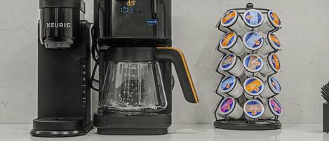 Una cafetera con pantalla digital, depósito de agua y compartimento para cápsulas de café.