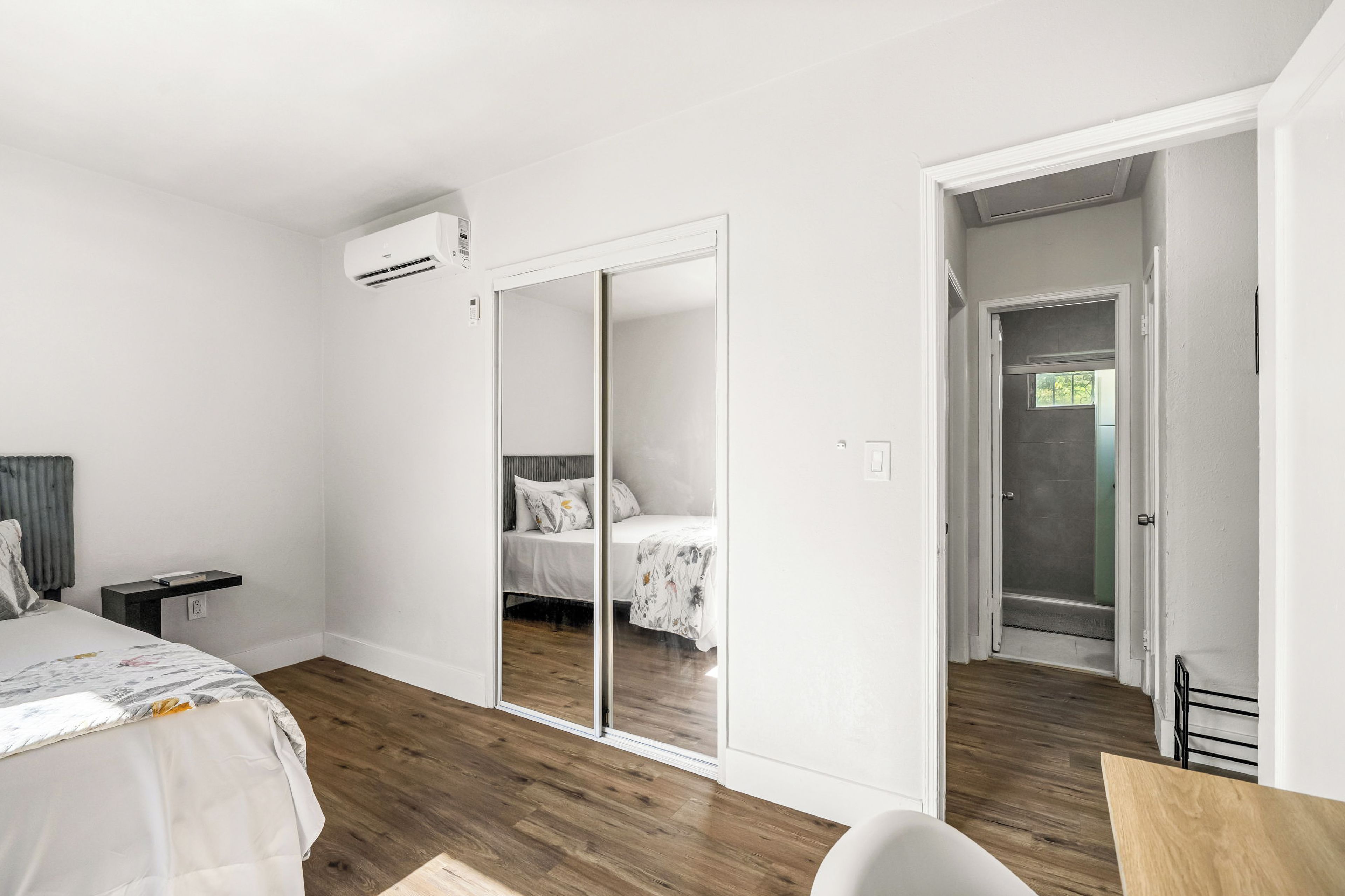 Un dormitorio con cama, mesita de noche, armario y zona de ducha.