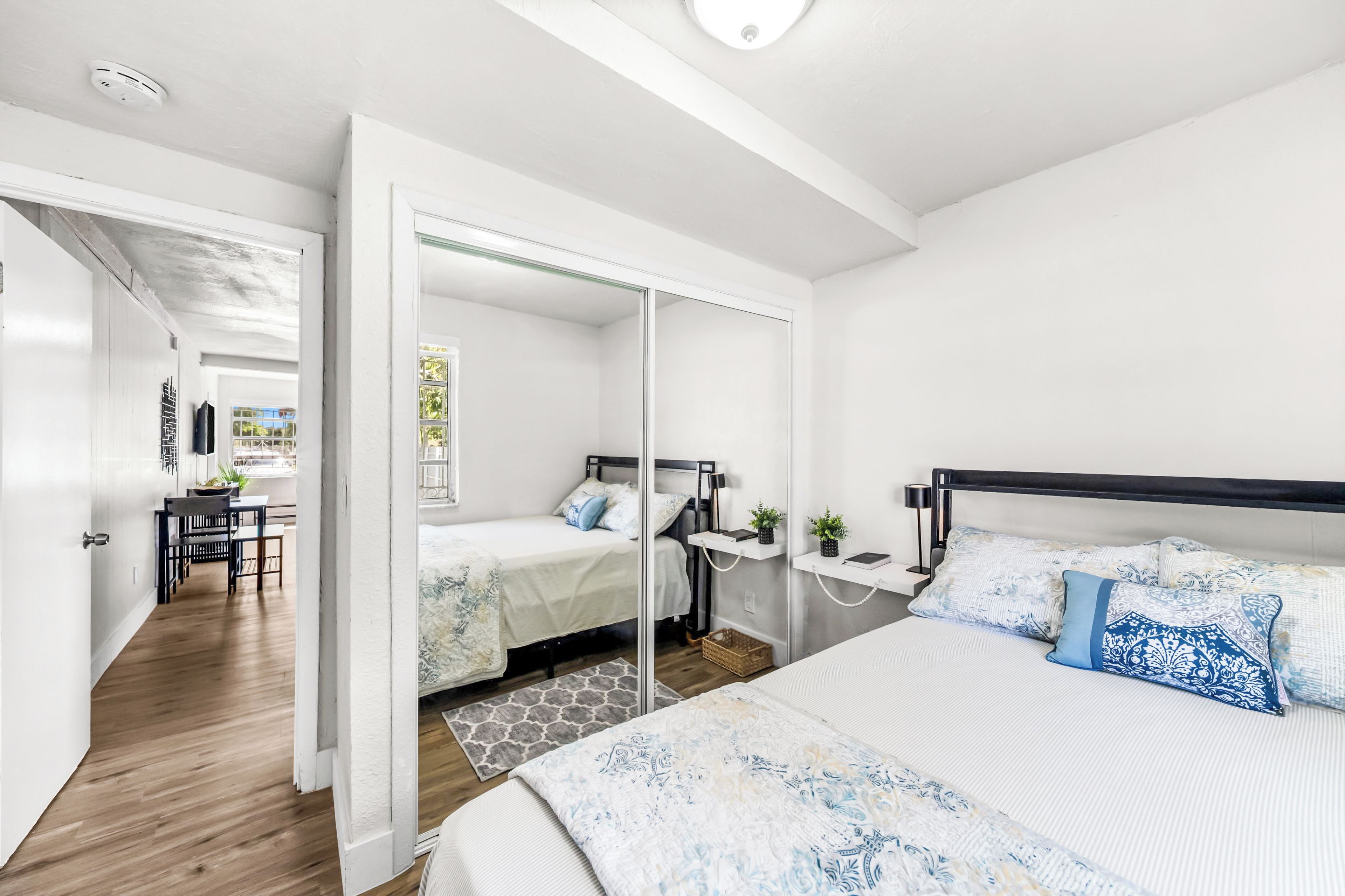 Un dormitorio moderno con una cama grande, un escritorio y un armario con espejo.