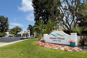 A sign for Ocean Hills Country Club with a clear road in the foreground. - Cute 2-bedroom Oceanside house in beautiful 55+ Ocean Hills Country Club (Oceanside)