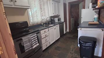 A kitchen with a stove, oven, microwave, and cabinets.
