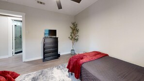 A bedroom with a bed, dresser, and a potted plant. - *NEW* Hullabaloo Hangout - 1.1 miles to Kyle Field! (College Station)