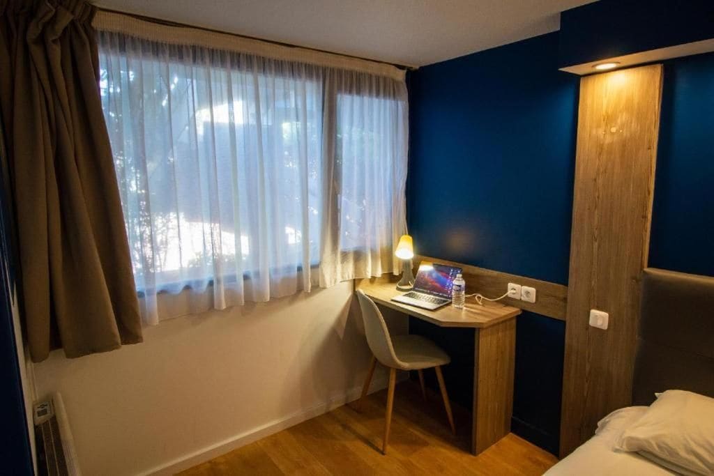 Una habitación con escritorio, silla y cama.