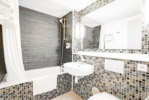 Une salle de bain avec une baignoire, un lavabo et une douche.