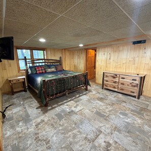 Ein Schlafzimmer mit einem Bett, einem Schminktisch, einem Nachttisch und einem Fernseher.