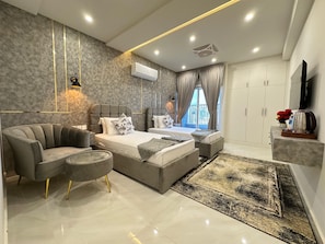 A modern bedroom with a bed, a sofa, a coffee table, and a TV.