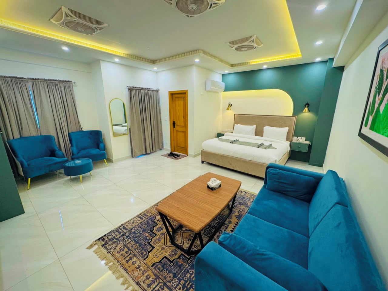 A modern living room with a sofa, a coffee table, and a bed with a headboard.