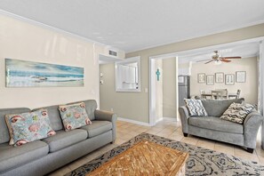 A living room with two sofas, a coffee table, and a painting on the wall. - Coastal Retreat at Admirals Row (Hilton Head Island)