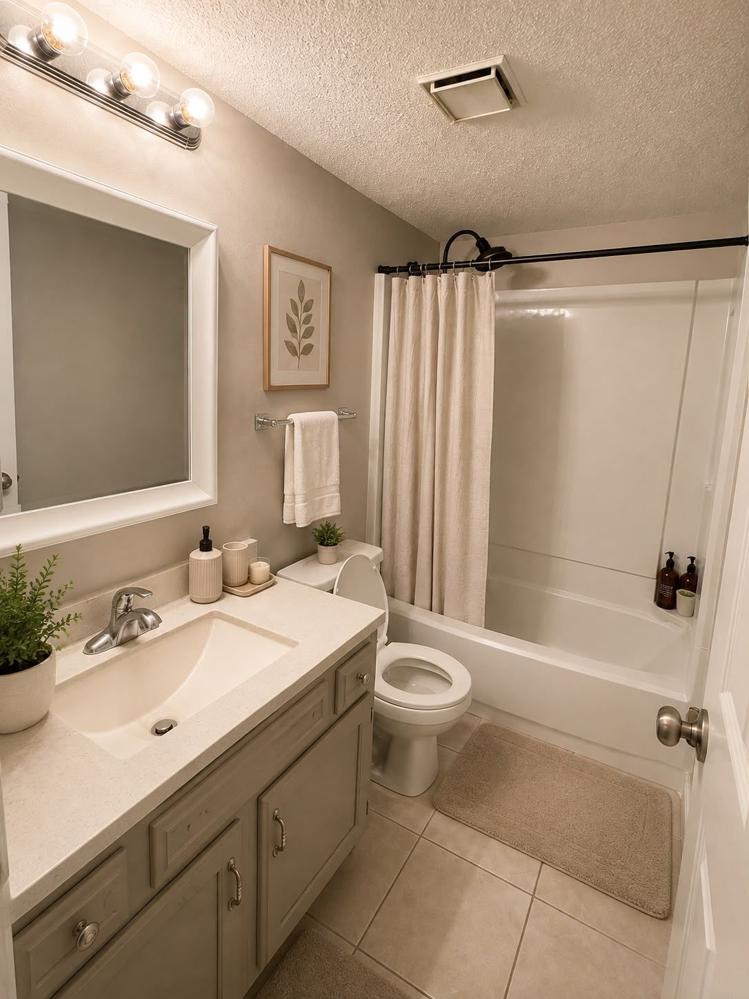 A bathroom with a sink, mirror, toilet, and shower area.