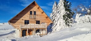 A wooden cabin with a balcony, surrounded by snow-covered trees and a clear sky. - Large 4-Star Chalet at Balné ô Sancy (Chastreix)
