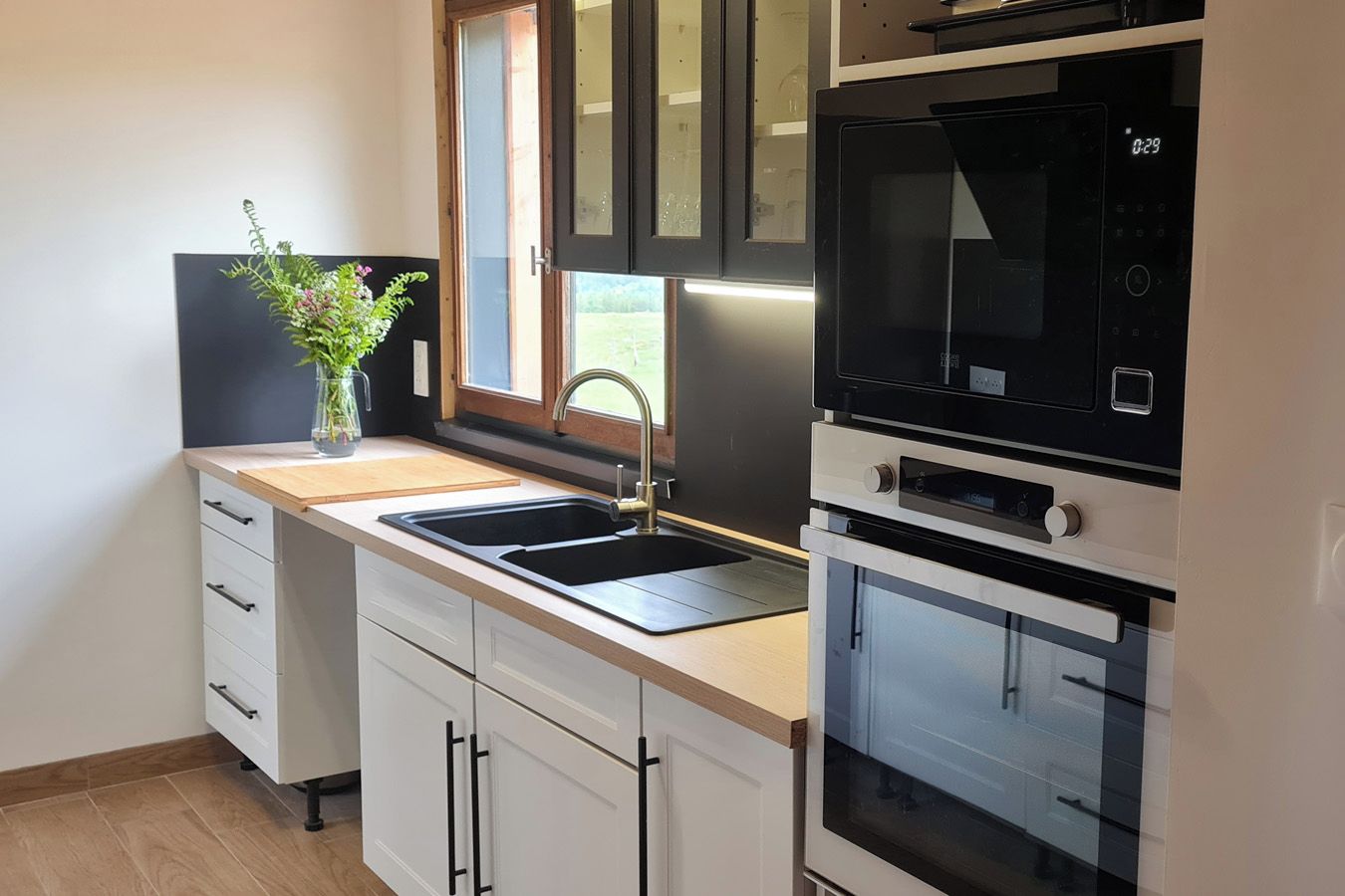 Una cocina moderna con un lavamanos, una ventana y electrodomésticos integrados.