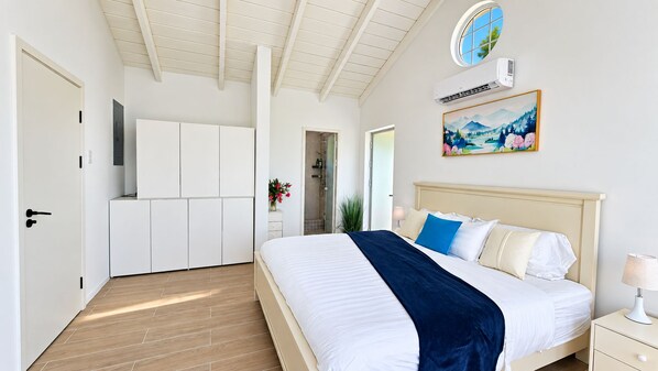 Un dormitorio con cama, mesita de noche y un cuadro en la pared.