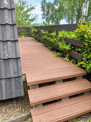 A wooden pathway leading to a building with a sloped roof.