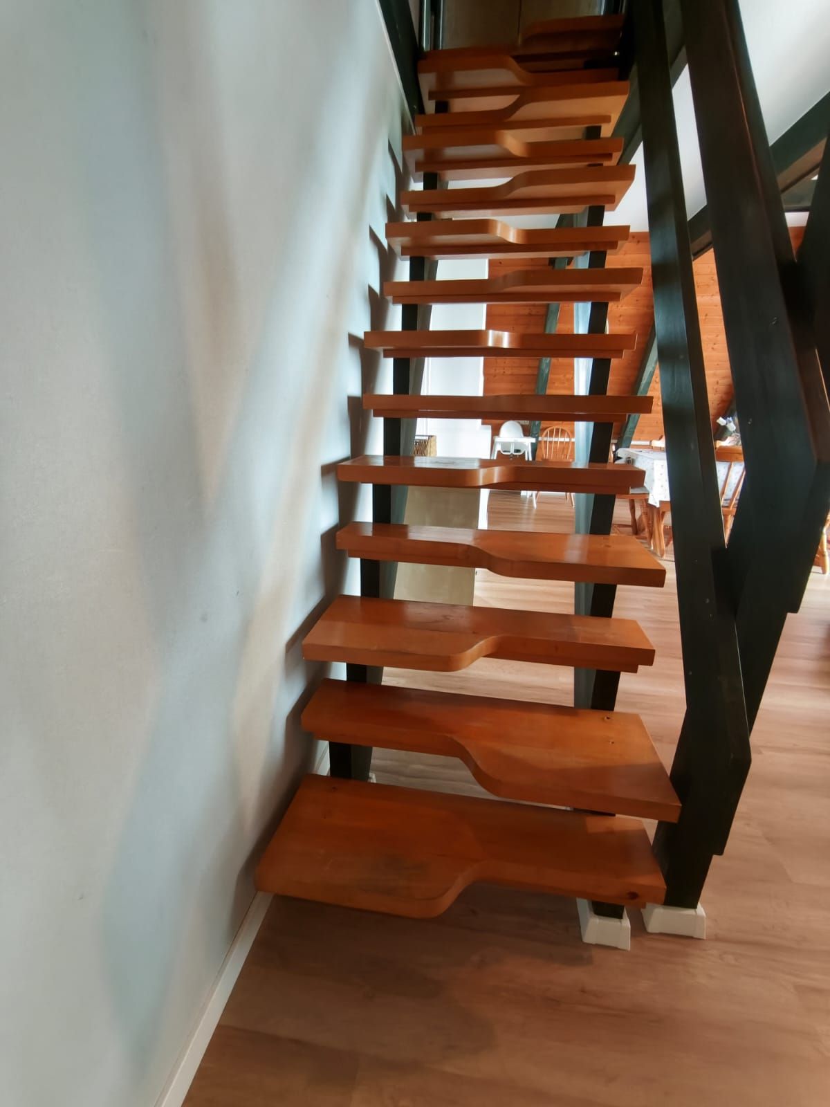 Una escalera de madera con diseño moderno que conduce a un piso superior.