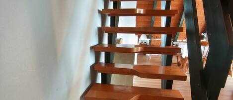 A wooden staircase with a modern design, leading to an upper floor.