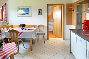 Ein Essbereich mit Tisch, Stühlen und einer Blumenvase.