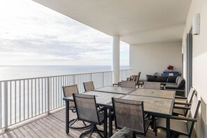 Ein Balkon mit Meerblick, ausgestattet mit einem Tisch, Stühlen und einer Sitzecke.