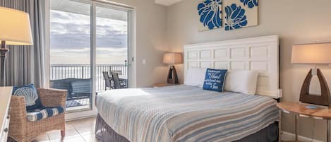 Une chambre d’hôtel avec un grand lit, un balcon et une vue sur la mer.