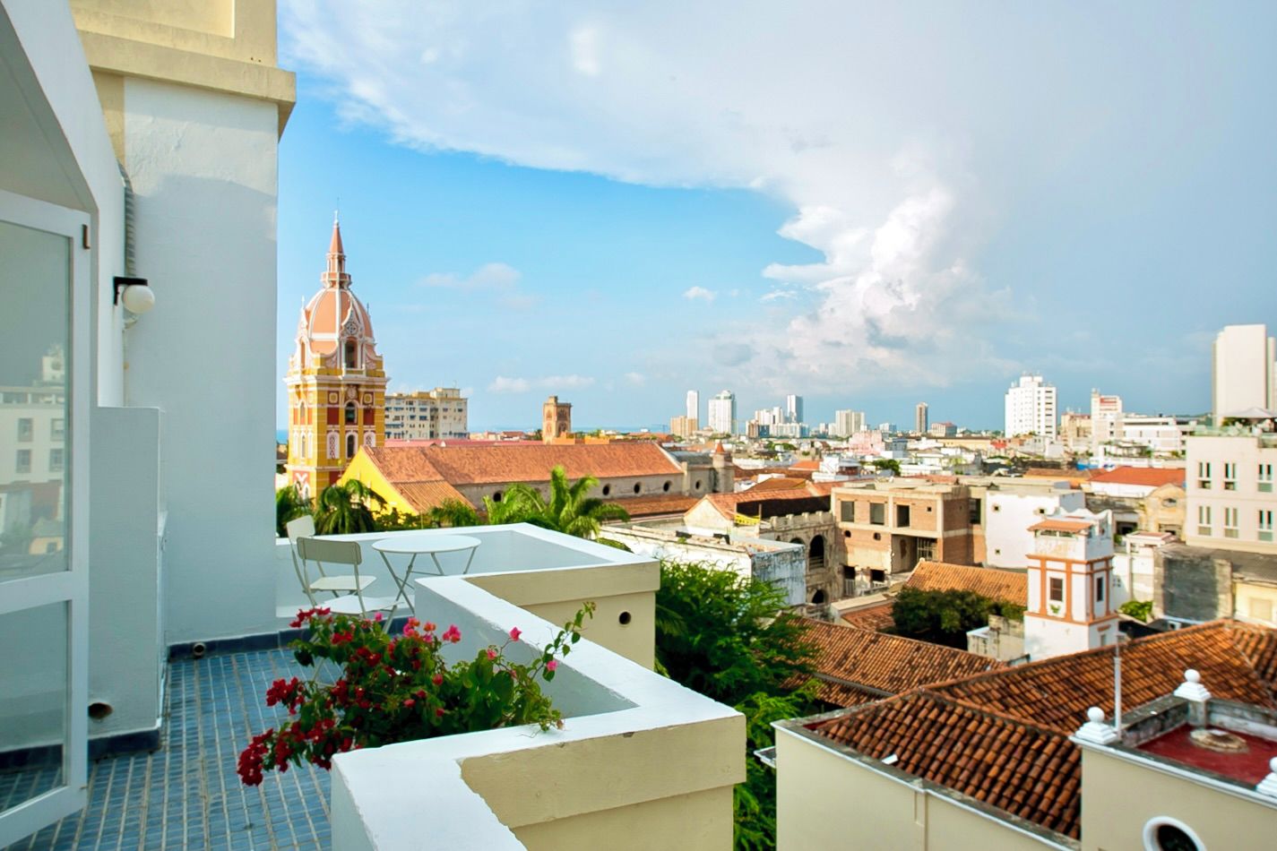 A balcony with a view of a cityscape, including a prominent church and various buildings.