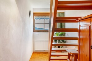 A wooden staircase leading to a room with a window, a radiator, and a plant. - Apartment 'Ferienwohnung Waldzauber' with Mountain View, Shared Terrace and Wi-Fi (Münstertal/Schwarzwald)