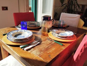 A wooden dining table with plates, cutlery, and a pitcher. - La Dimora Torlonia Elegance & Light in Rome (Roma)