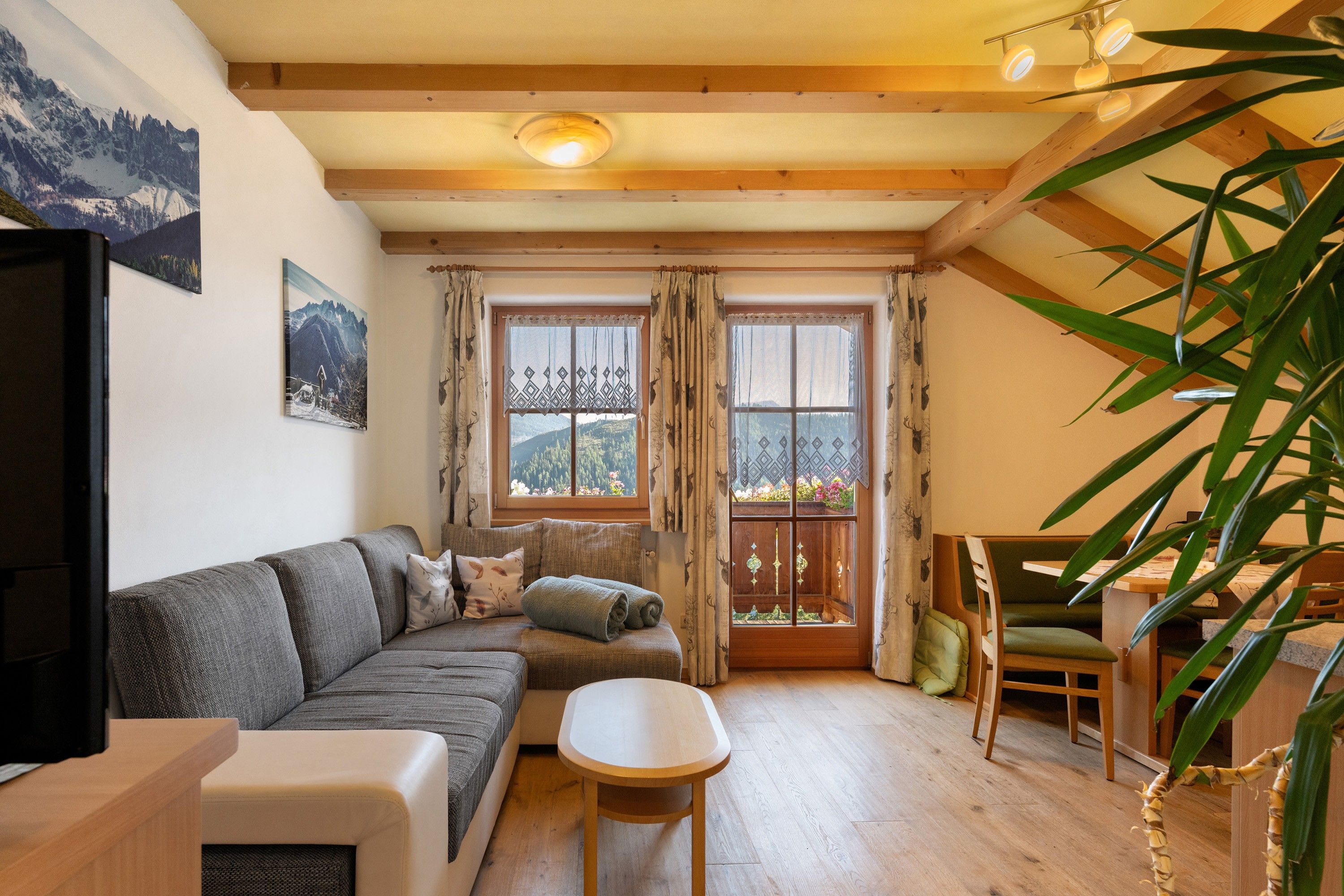 Un salon confortable avec un canapé, une petite table et une vue sur une montagne par la fenêtre.