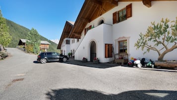 Un bâtiment doté d’un toit en pente, de poutres en bois et d’une allée gravillonnée.