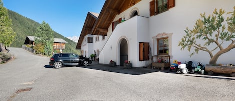 Ein Gebäude mit einem geneigten Dach, Holzbalken und einer Schotterauffahrt.