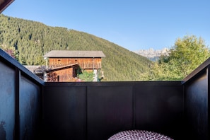 Una habitación con vista a una cabaña de madera y una montaña.