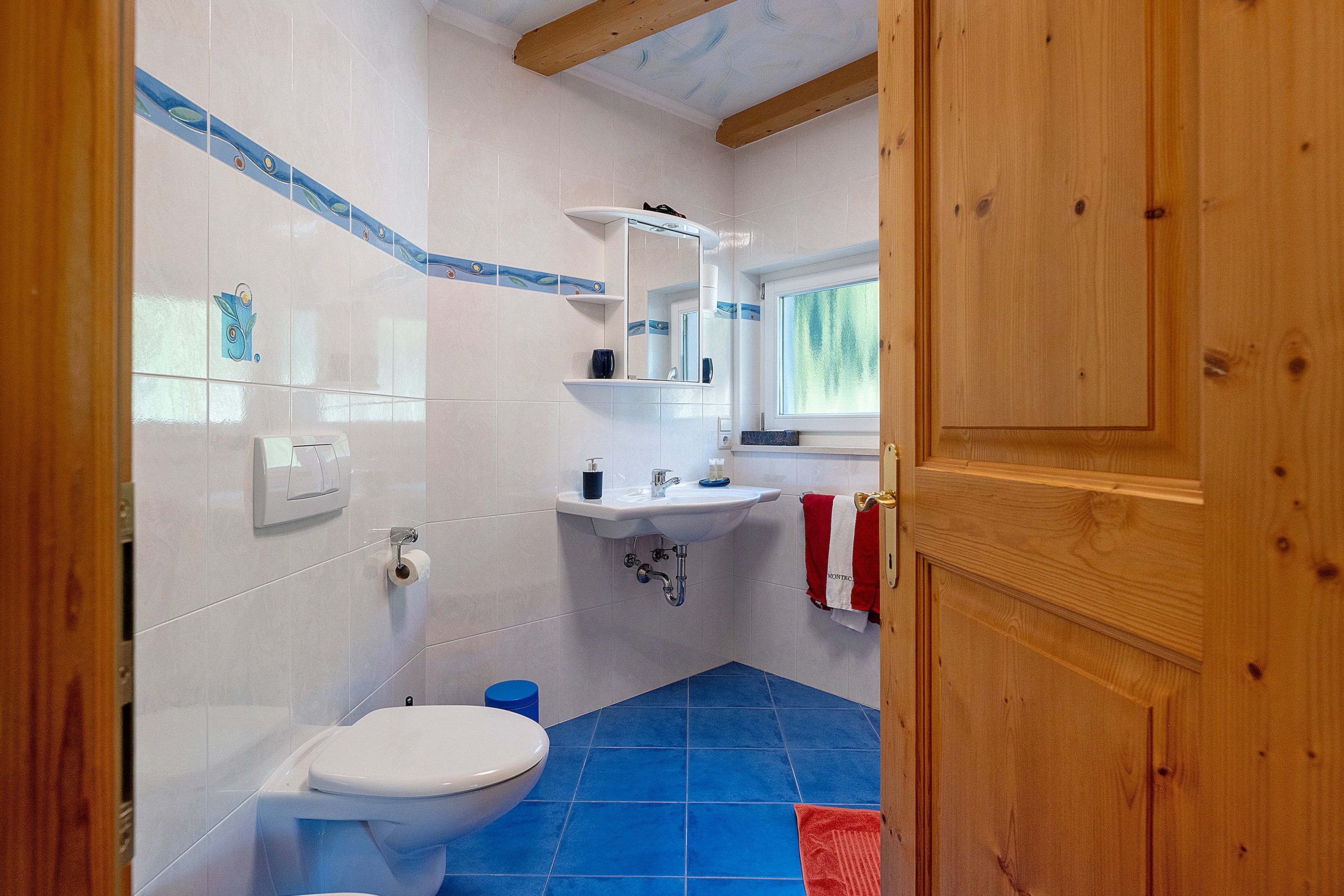 Une salle de bain avec des toilettes, un lavabo et un miroir.