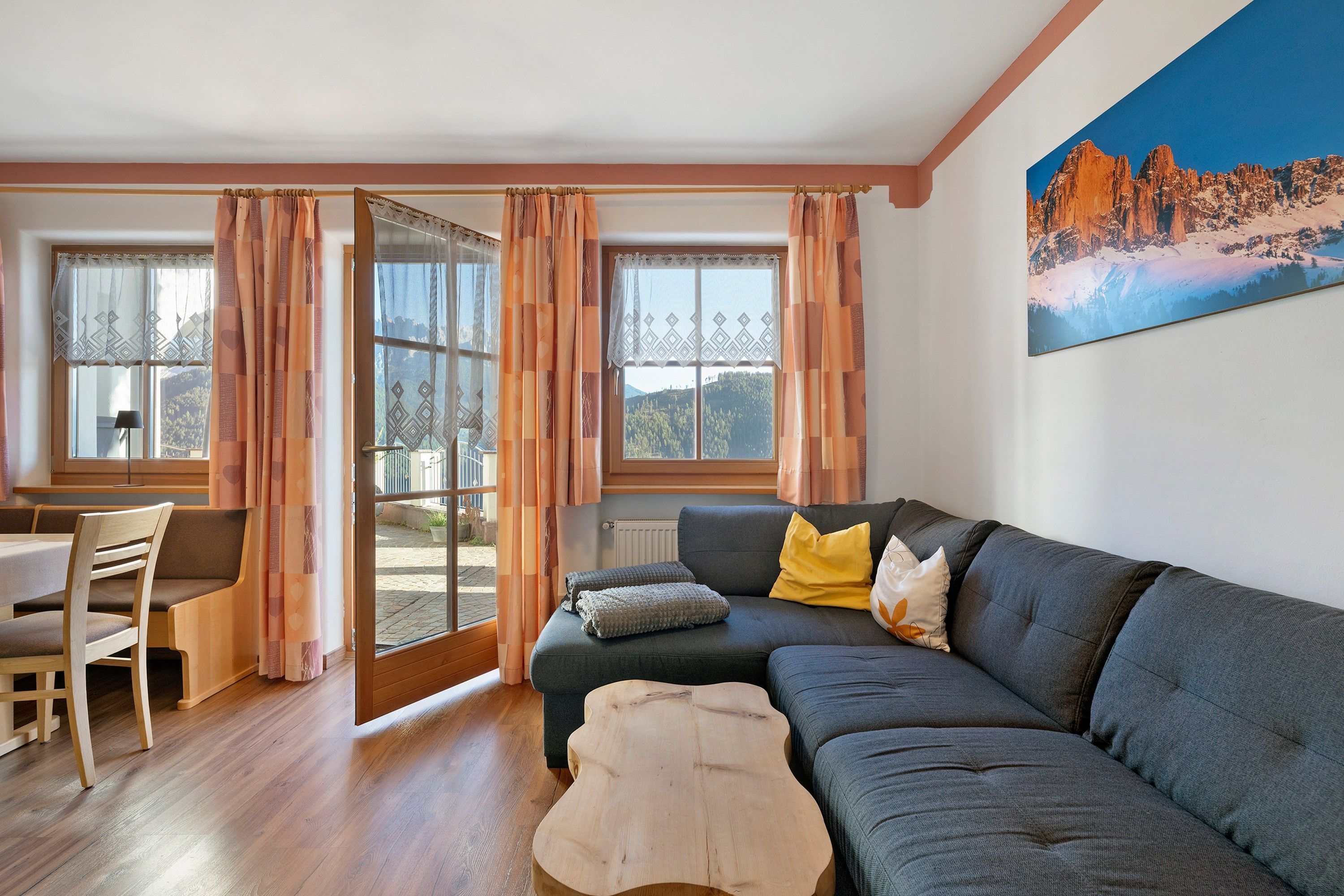 A cozy living room with a sofa, a wooden coffee table, and a dining area with a chair and table.