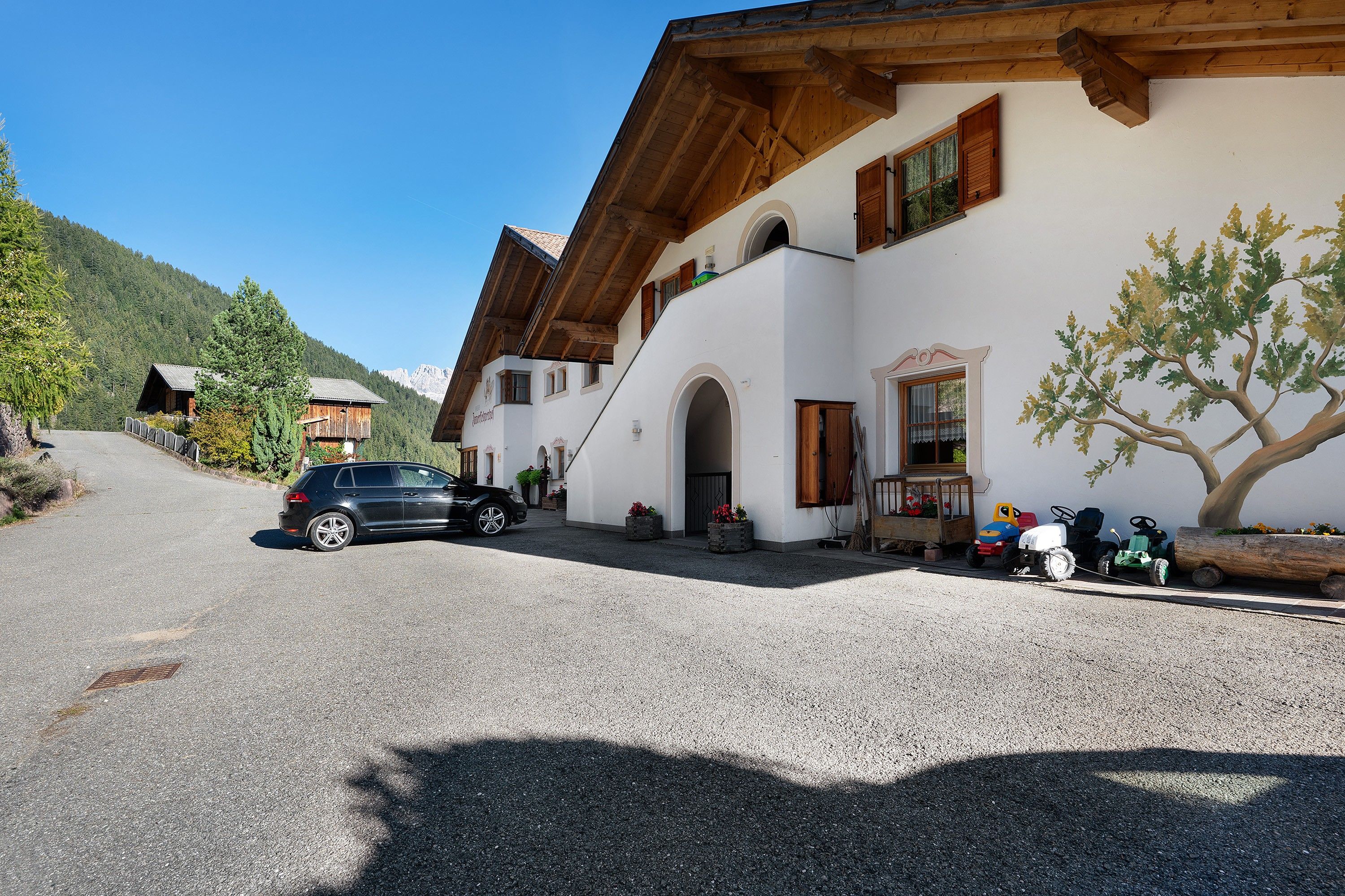 Un bâtiment doté d’un toit en pente, de poutres en bois et d’une allée gravillonnée.