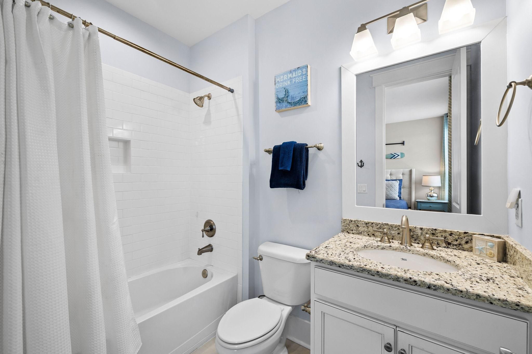 A bathroom with a bathtub, toilet, and sink.