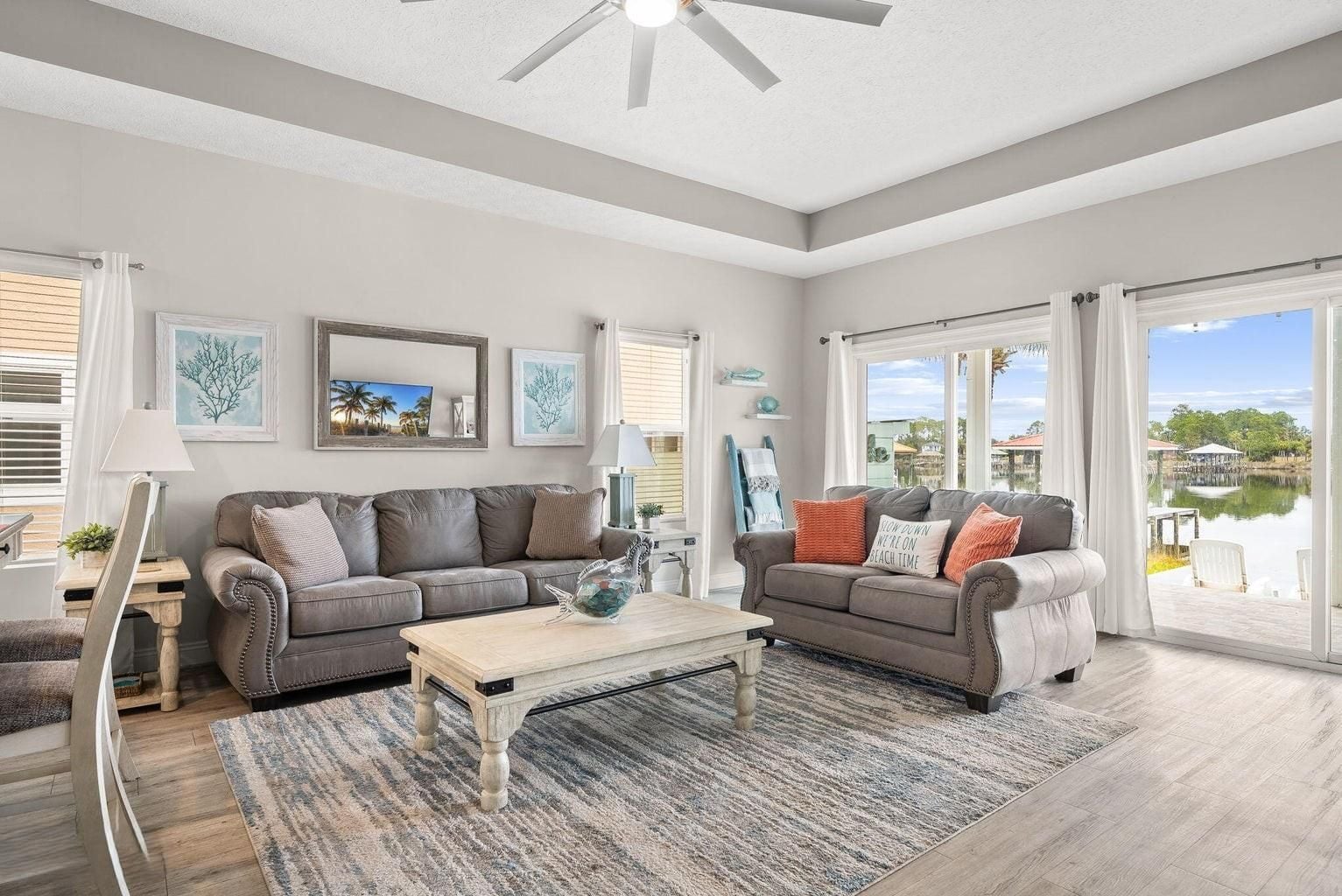 A spacious living room with two sofas, a coffee table, and a ceiling fan.