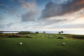 A golf course with a view of the ocean and a cloudy sky. - Top-View Oceanside 2BR Villa, Beachfront Marriott St. Kitts – Dec 8–15, Sleeps 8 (Frigate Bay)