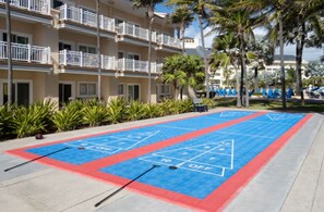 A shuffleboard court with a building in the background. - Top-View Oceanside 2BR Villa, Beachfront Marriott St. Kitts – Dec 8–15, Sleeps 8 (Frigate Bay)