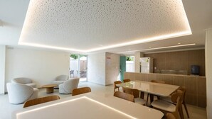 A modern interior with a dining area, seating, and a kitchen. - BNB Flex Premium (Recife)